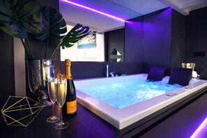 A modern spa area with a hot tub, champagne, and decorative items. - Ultra-Luxury Private Spa Suite at the Spanish Steps (Roma)