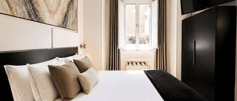 Une chambre d’hôtel avec un lit, une télévision et une fenêtre avec des rideaux.