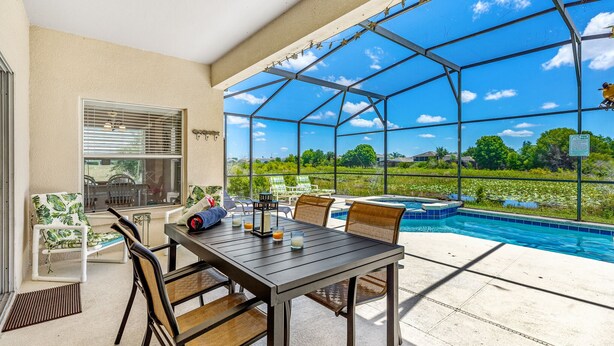 A covered patio area with a pool, outdoor seating, and a view of the landscape. - Stunning 4 Bed Villa With Uninterupted Lake Views In The Sanctuary  (Davenport)