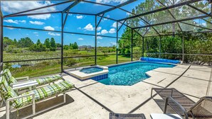 A covered outdoor swimming pool with lounge chairs and a hot tub, surrounded by trees and a clear sky. - Stunning 4 Bed Villa With Uninterupted Lake Views In The Sanctuary  (Davenport)