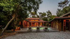 A house with a swimming pool, lounge chairs, and a covered patio area. - Charming house in Cap Ferret with private pool in a haven of peace (Lège-Cap-Ferret)