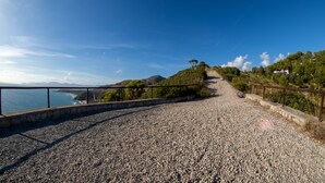 A gravel path leading to a coastal area with a clear view of the sea and distant mountains. - Splendid Villa with private pool and stunning views in Sperlonga, near Rome (Sperlonga)