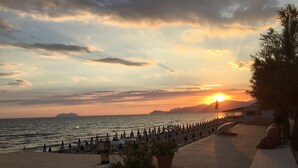 A beachside view with a sunset, umbrellas, and potted plants. - Splendid Villa with private pool and stunning views in Sperlonga, near Rome (Sperlonga)