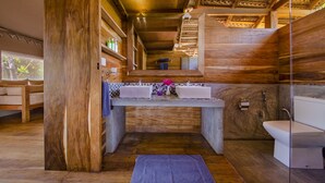 A wooden cabin bathroom with a sink, toilet, and shower.
