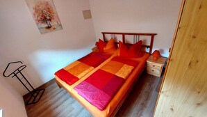 Una cama con cabecera de madera y una mesita de noche con lámpara.