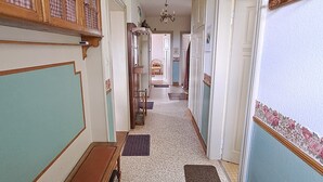 Un corridoio con una panchina, un lampadario e una porta decorata con un bordo floreale.