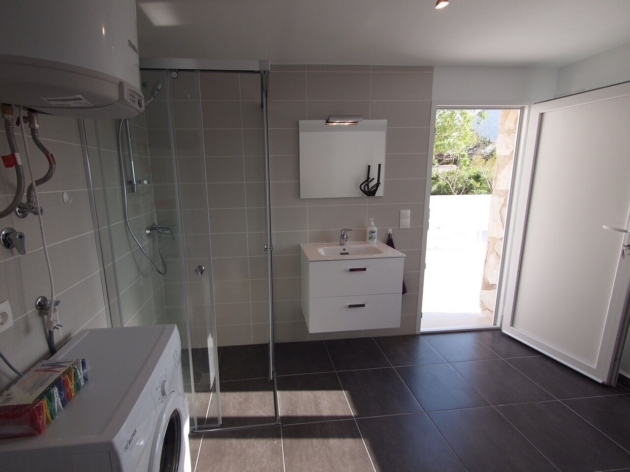 A modern bathroom with a glass shower enclosure, a built-in sink, and a toilet.
