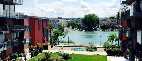 A modern building with a courtyard, a river view, and a swimming pool.