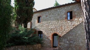 A stone building with a courtyard, featuring a small arched entrance and a window. - Vacation in a former monastery from the 14th century - Loggia apartment (Colle Val Elsa)