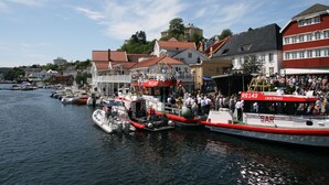 A harbor with boats docked, buildings with red roofs, and a crowd of people. - panorama view, modern apartment, quiet location, canoe, sauna (Amli/Felle)