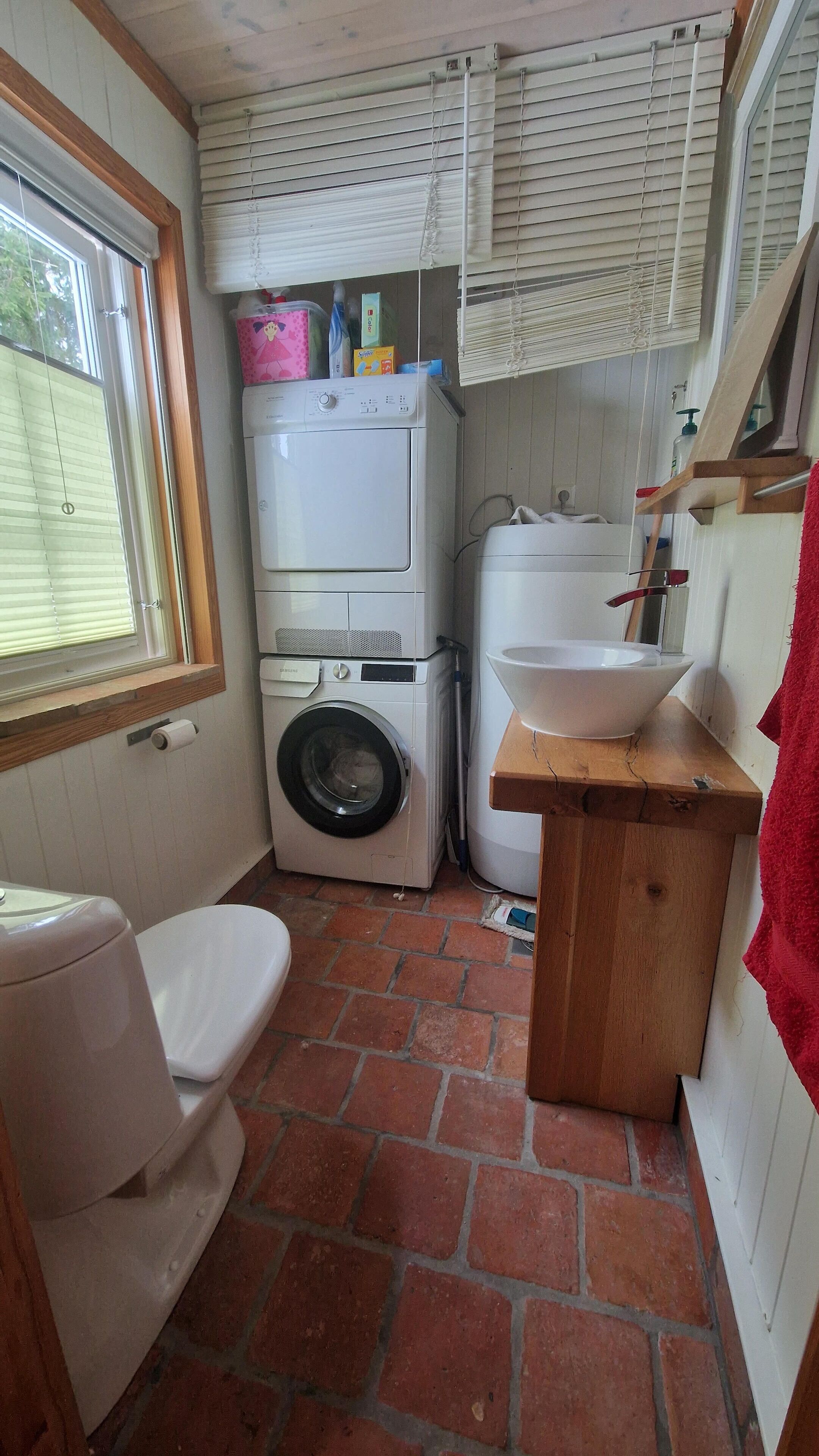 Un baño pequeño con lavadora, lavamanos y retrete.