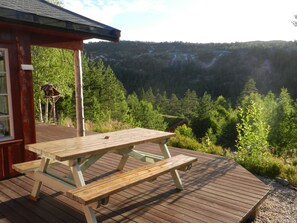 Eine Holzdar Terrasse mit Picknicktischen mit Blick auf ein bewaldetes Tal.