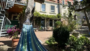 Un hamac dans une cour, avec un bâtiment en briques en arrière-plan.