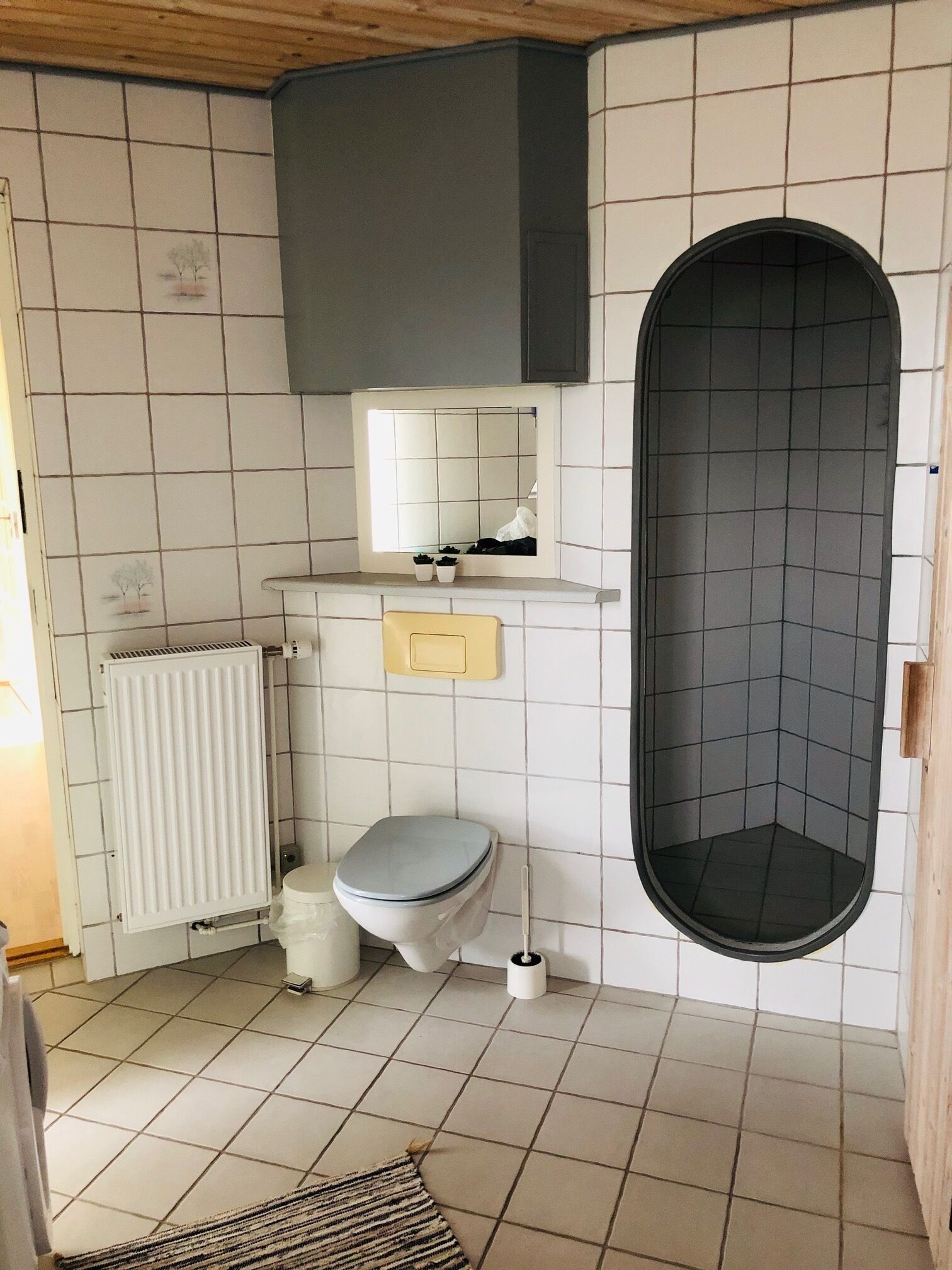 Un baño pequeño con inodoro, lavamanos, espejo y ducha.