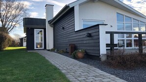 Ein modernes, zweistöckiges Haus mit gepflasterter Auffahrt und einem kleinen Garten.