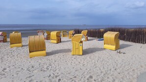 A beach with yellow wicker chairs arranged in rows. - 3-star ground floor, free Wi-Fi, near the coast in Otterndorf (Neuenkirchen)