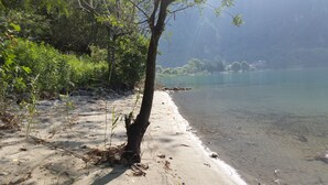 Una playa con agua cristalina, rodeada de vegetación y rocas.