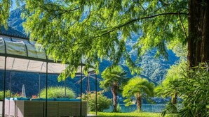 Un espacio de estar techado al aire libre con vista a un lago y montañas.
