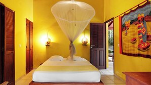 A room with a bed, wooden doors, and a wall with a mural. - Kaz a Coco, Yellow Villa 2 bdrms, private pool (Deshaies)