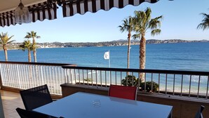 A balcony with a table and chairs overlooking a coastal view. - 4-room apartment 90 m² + Terrace 17 m². Sea Front, Panoramic Sea View (Bandol)