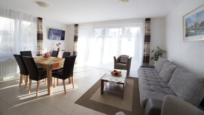 Ein modernes Wohnzimmer mit Essbereich, einer Couch und einem Couchtisch.