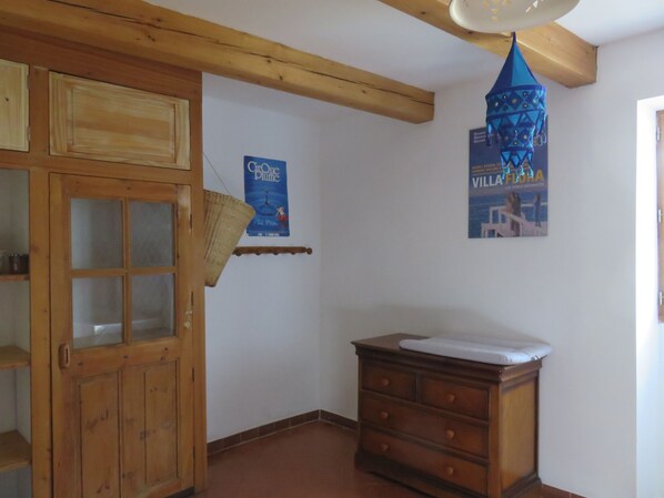 A room with a wooden cabinet, a dresser, and a poster on the wall.