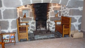 Una chimenea de piedra con un banco de madera y una mesita auxiliar a su lado.