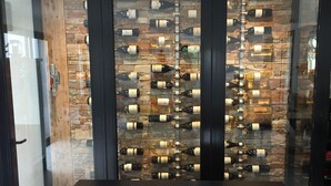 A modern interior with a central island and a wall displaying numerous wine bottles.