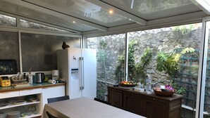 Una cuina compacta amb nevera, cafetera i taula de dinar amb cadires.