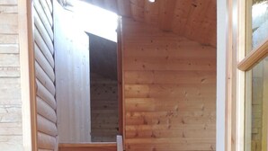A wooden staircase leading to a loft area with a door and a window.