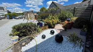 A garden with white pebbles, potted plants, and a wooden fence. - Villa in Sainte Marine. heated pool. beaches, harbour, all on foot  (Combrit)
