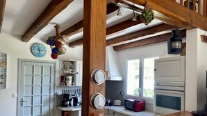Eine Küche mit Holzbalken, einer weißen Tür und einem Fenster.