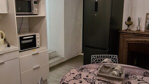 Une cuisine compacte équipée d’une table à manger, d’un four à micro-ondes et d’un réfrigérateur.
