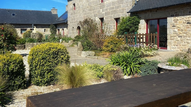 A stone building with a wooden deck and a picnic table in front. - Domaine de Kerzuat - Chambres d'hôtes (Plouarzel)