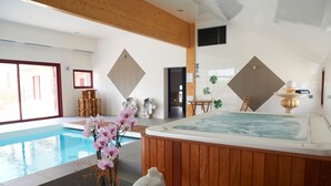 A spa area with a hot tub, a pool, wooden beams, and a view of the outdoors. - Domaine de Kerzuat - Chambres d'hôtes (Plouarzel)