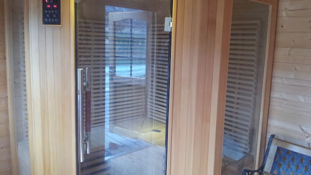 Un intérieur en bois avec une porte en verre donnant sur une pièce.