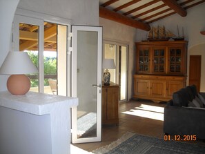 Relax in a stylish living room with a sliding door to the outdoors, a sofa, and a wooden cabinet with glass doors.