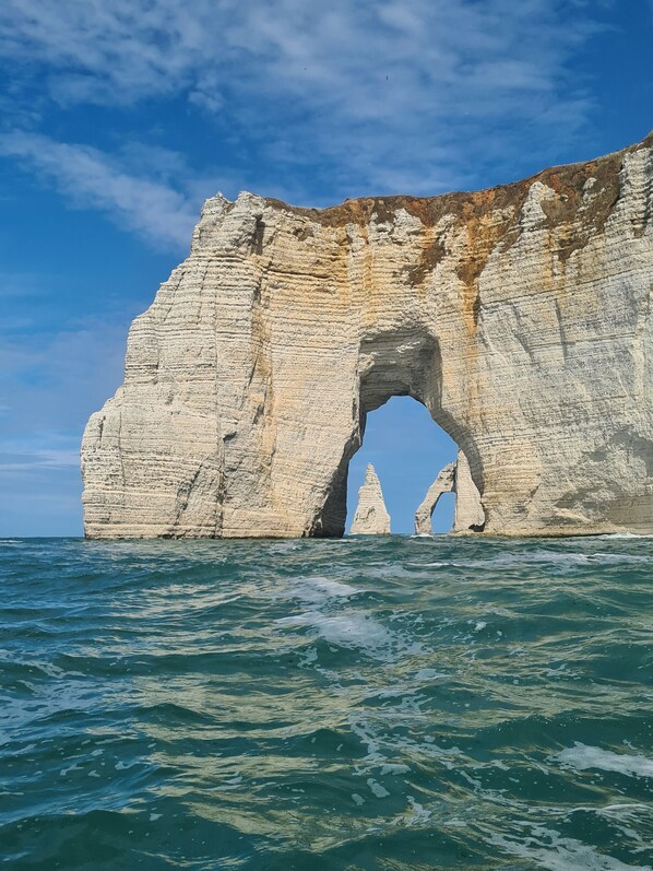 A coastal cliff with a natural arch formation.