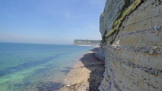 A coastal cliff with a clear view of the sea and a distant shoreline. - South-facing, cocooning gîte 40 m from the sea, rated 3***. (Fécamp)