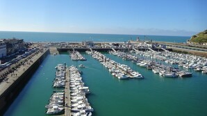A marina with numerous boats docked, a clear sky, and a view of the sea. - South-facing, cocooning gîte 40 m from the sea, rated 3***. (Fécamp)