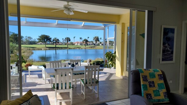 A room with a view of a lake, a ceiling fan, and a table with chairs. - Beautiful 3 Bedroom 2 Bath Home in a Resort-like Community.   (North Fort Myers)