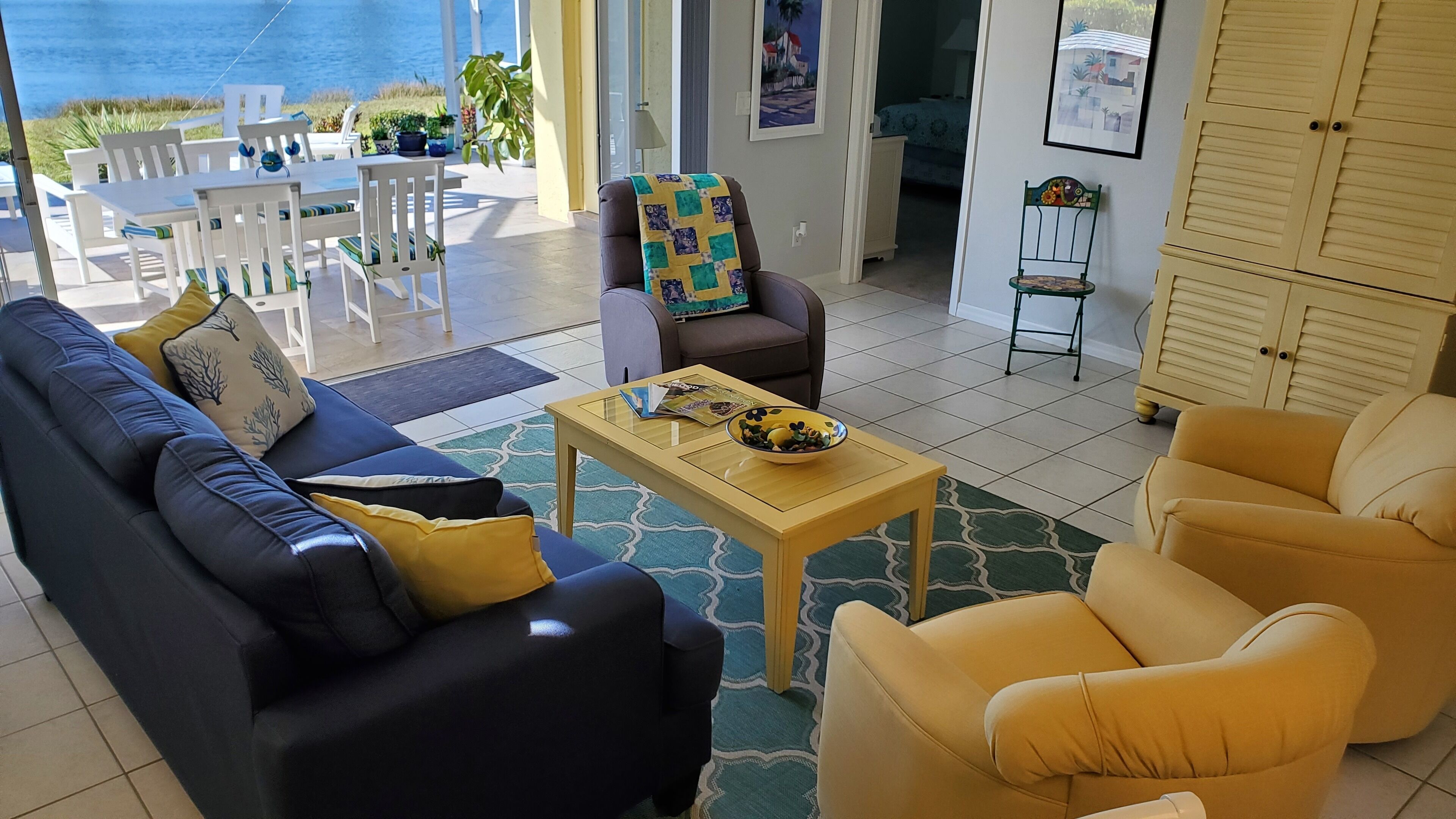 Un salon comprenant un canapé, des fauteuils, une table basse et une vue sur la mer.