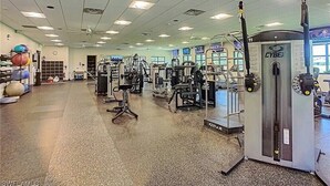 A gym with various exercise machines, a ceiling fan, and a large window. - Beautiful 3 Bedroom 2 Bath Home in a Resort-like Community.   (North Fort Myers)