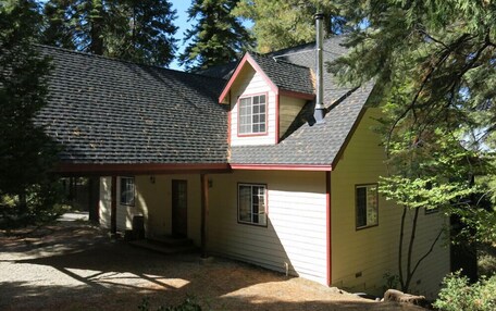 A single-story house with a sloped roof, a chimney, and a front porch.