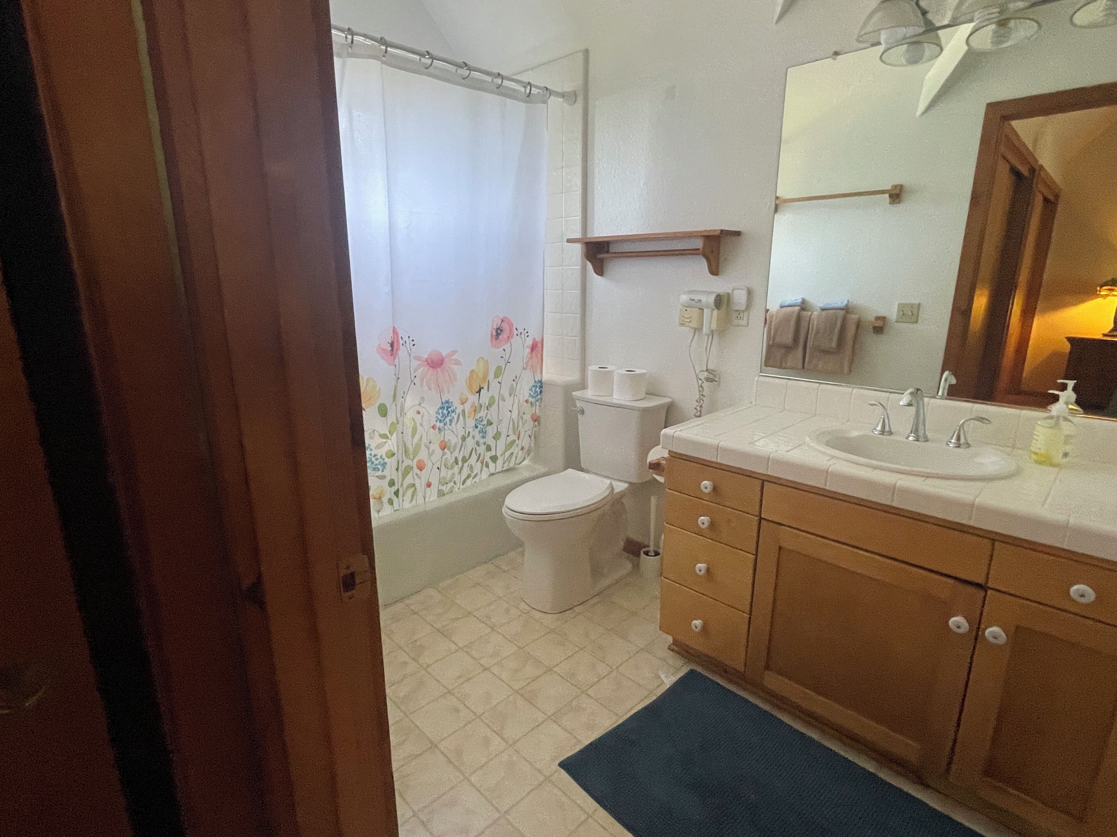 A bathroom with a toilet, sink, and shower curtain.