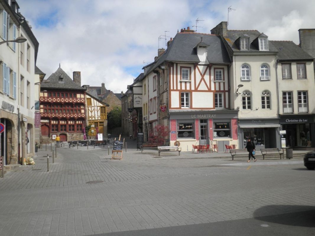 A cobblestone street with historic buildings, including a restaurant named "Le Mariray" and a shop called "Christine du Lac".