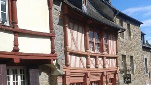 Un edificio tradicional con entramado de madera, fachada de piedra y una calle adoquinada.
