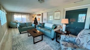 A living room with a sofa, armchairs, a coffee table, and a rug. - Waterfront Home on Canal - Heated Pool, Free use of Pontoon Boat! Discount's (New Port Richey)