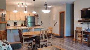 A modern kitchen with wooden cabinets, a stainless steel refrigerator, and pendant lighting. - Premium 2 Bedroom, 2 Bath Condo w/central Air Conditioning- Lodges at Canmore (Canmore)