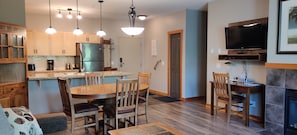Cozy living space with a dining area, kitchen, and fireplace.